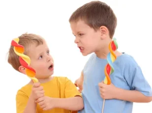 агрессивный ребенок с конфетой в руке